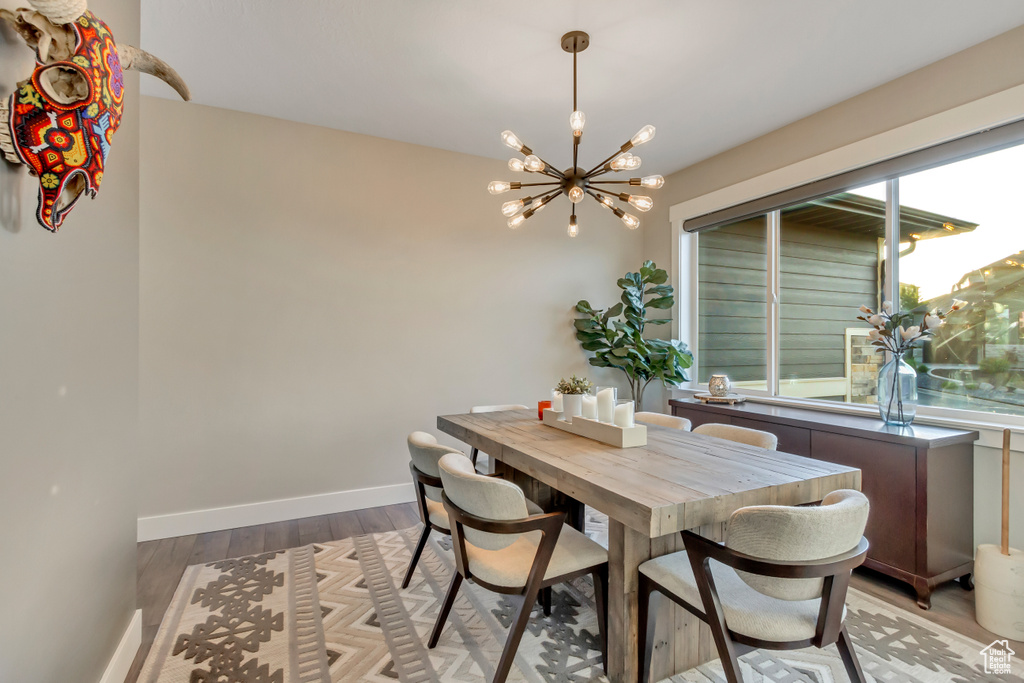 Dining space featuring a chandelier, light wood-style floors, and baseboards