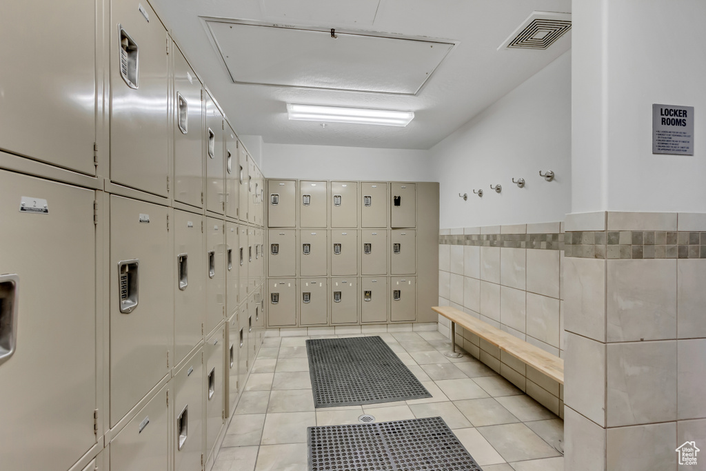 View of property's community featuring stacked washer / dryer, tile walls, and mail area