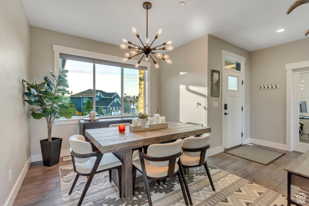 Dining area with a chandelier, light wood-style flooring, baseboards, and recessed lighting