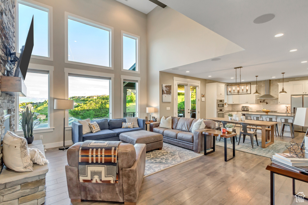 Living room featuring light wood-style flooring, recessed lighting, and a high ceiling
