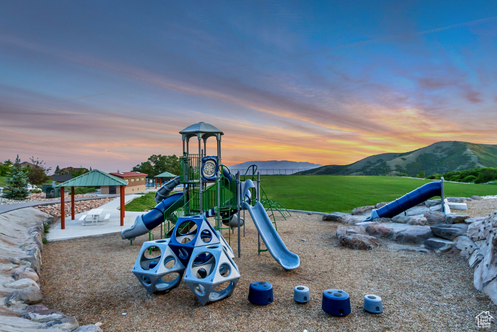 Playground at dusk featuring a mountain view and a gazebo
