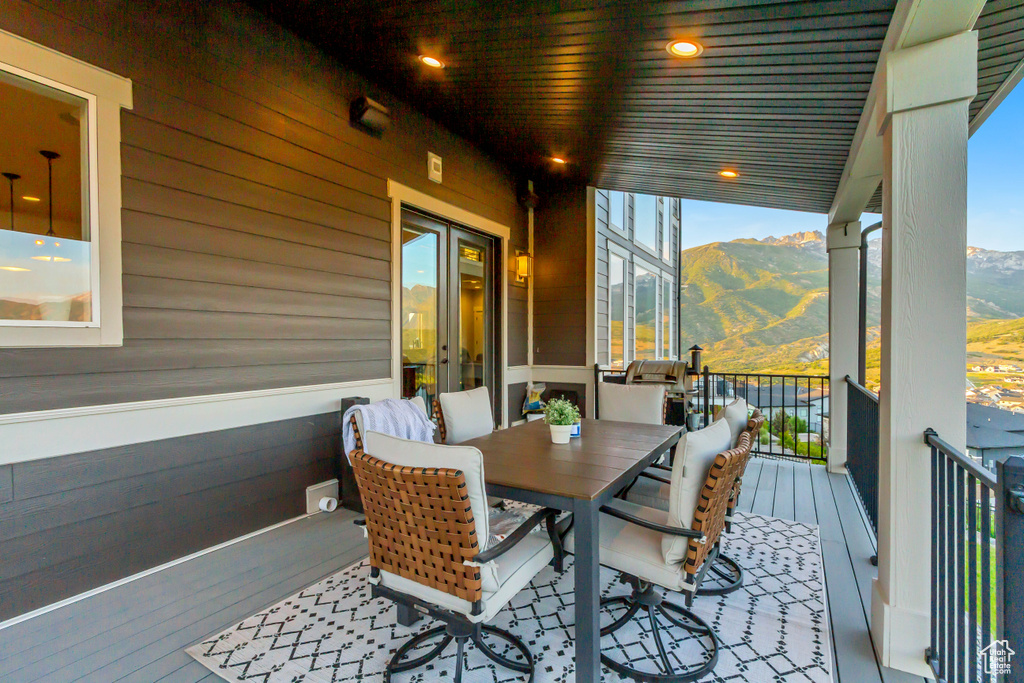 Wooden deck featuring a mountain view and outdoor dining area