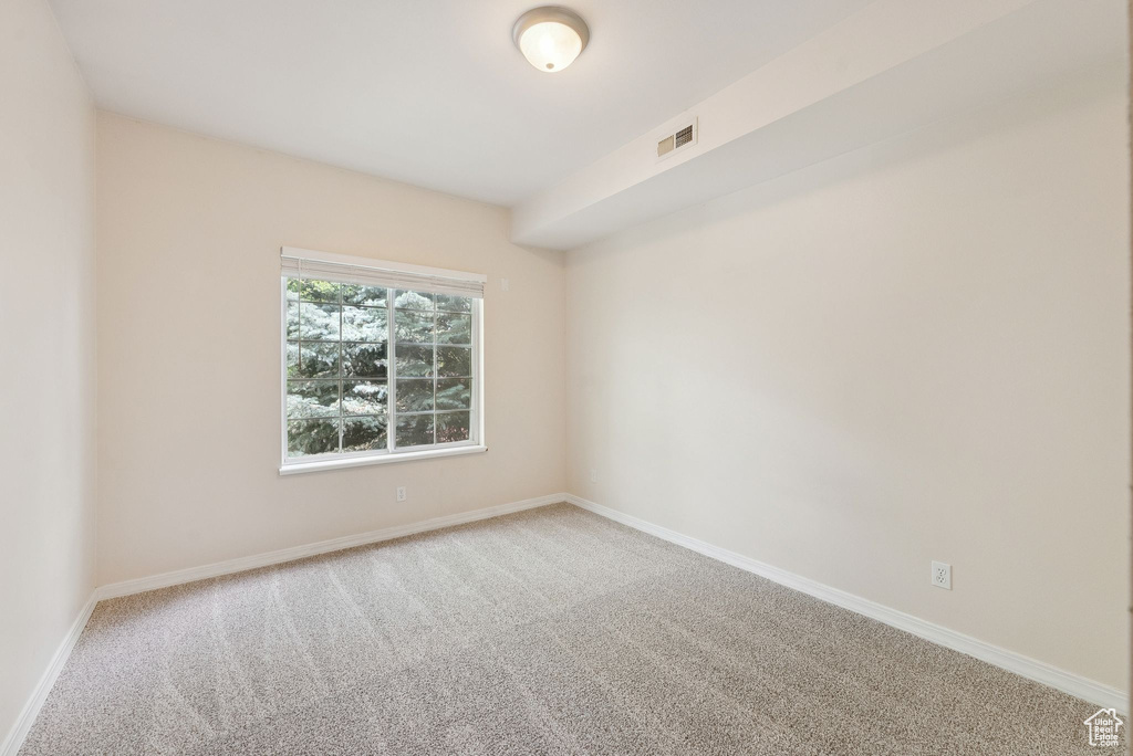 Carpeted spare room with baseboards