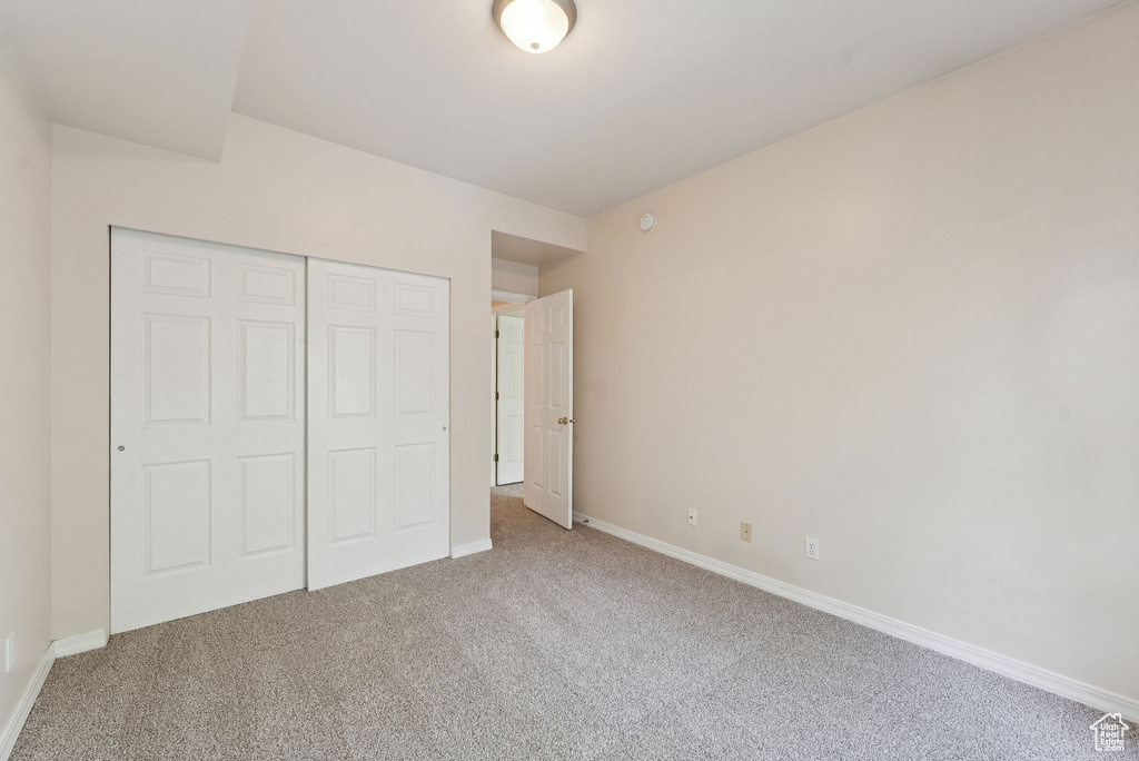Unfurnished bedroom featuring carpet flooring, a closet, and baseboards
