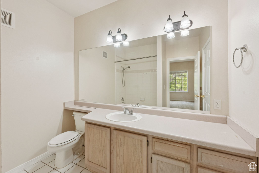 Bathroom with a shower, toilet, tile patterned floors, vanity, and baseboards