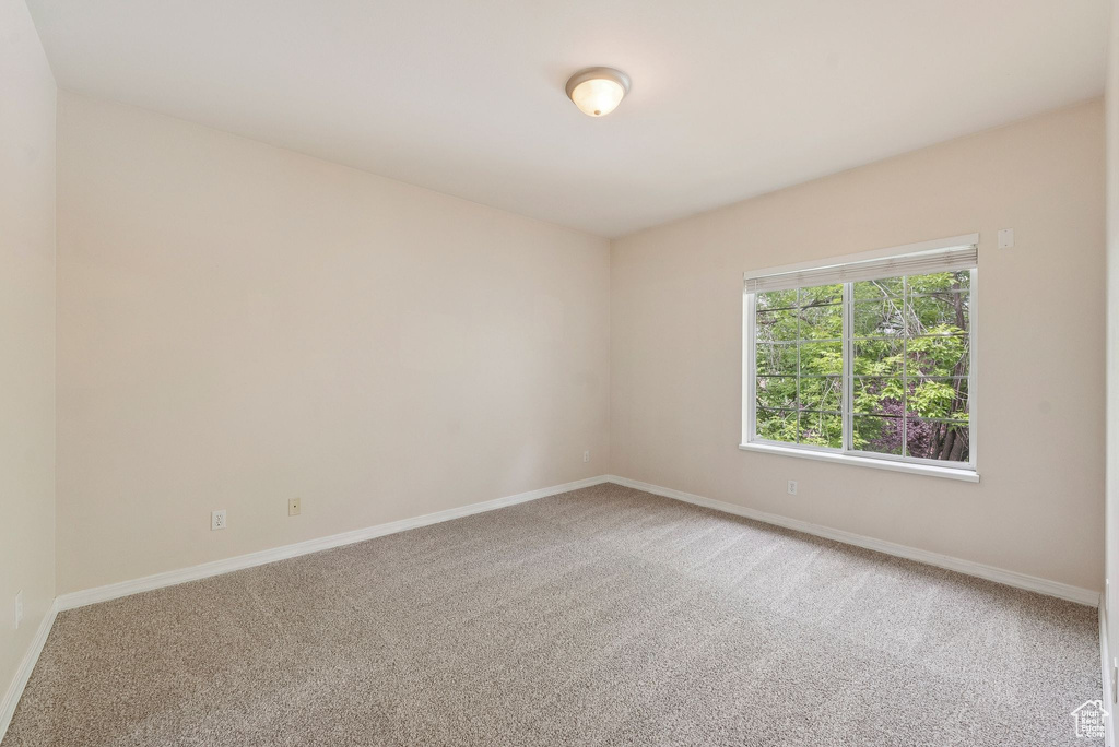 Carpeted spare room with baseboards