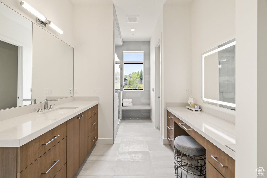 Full bathroom featuring vanity, baseboards, and tile patterned floors