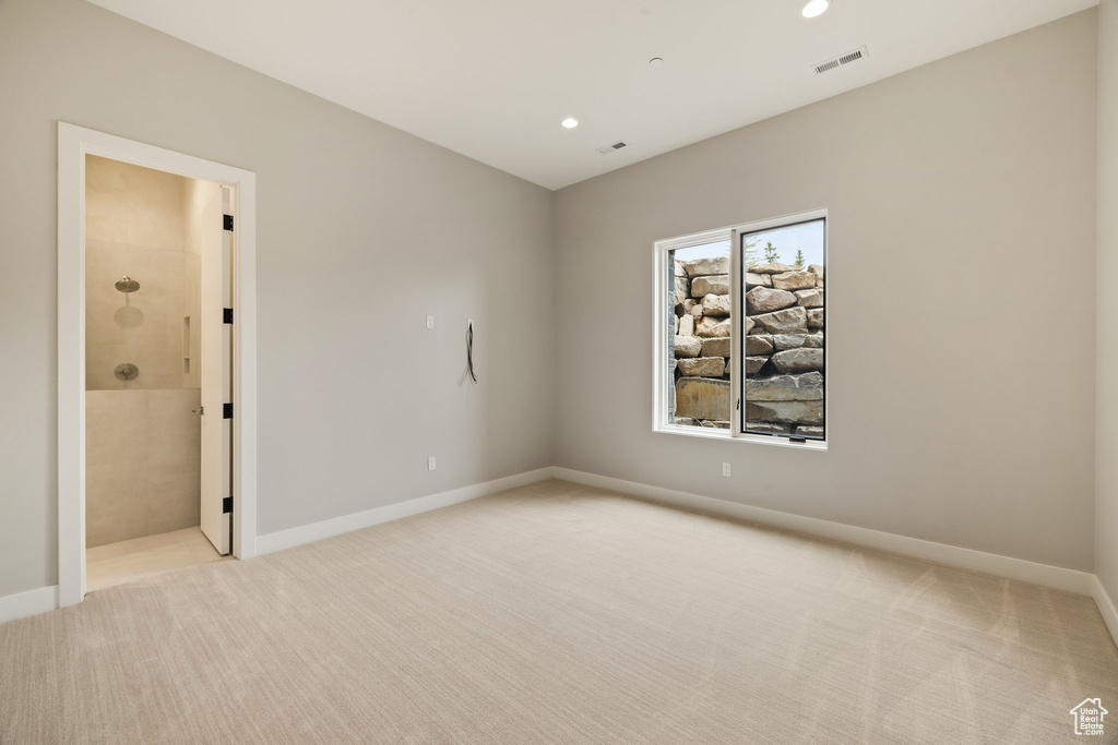 Empty room featuring light colored carpet, recessed lighting, and baseboards