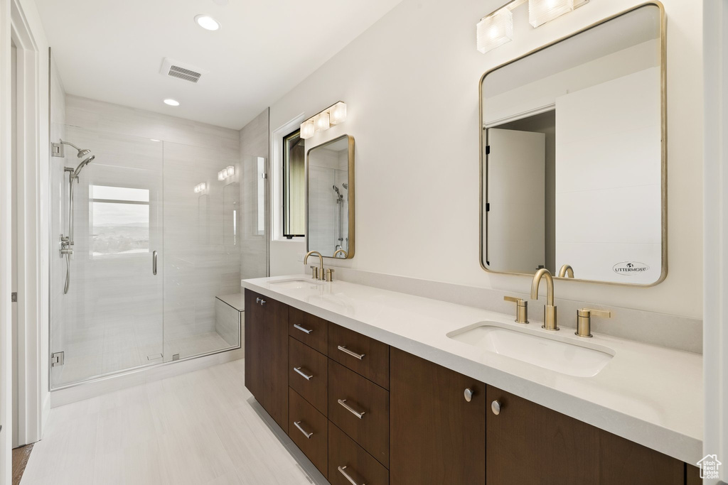 Bathroom with double vanity, a stall shower, and recessed lighting