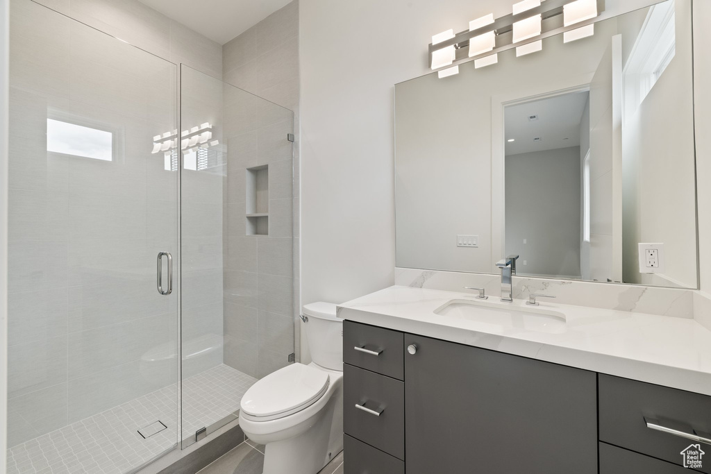 Full bathroom with vanity, toilet, and a stall shower