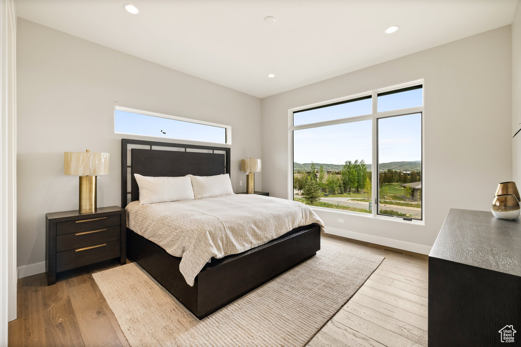 Bedroom featuring hardwood / wood-style flooring, baseboards, and recessed lighting