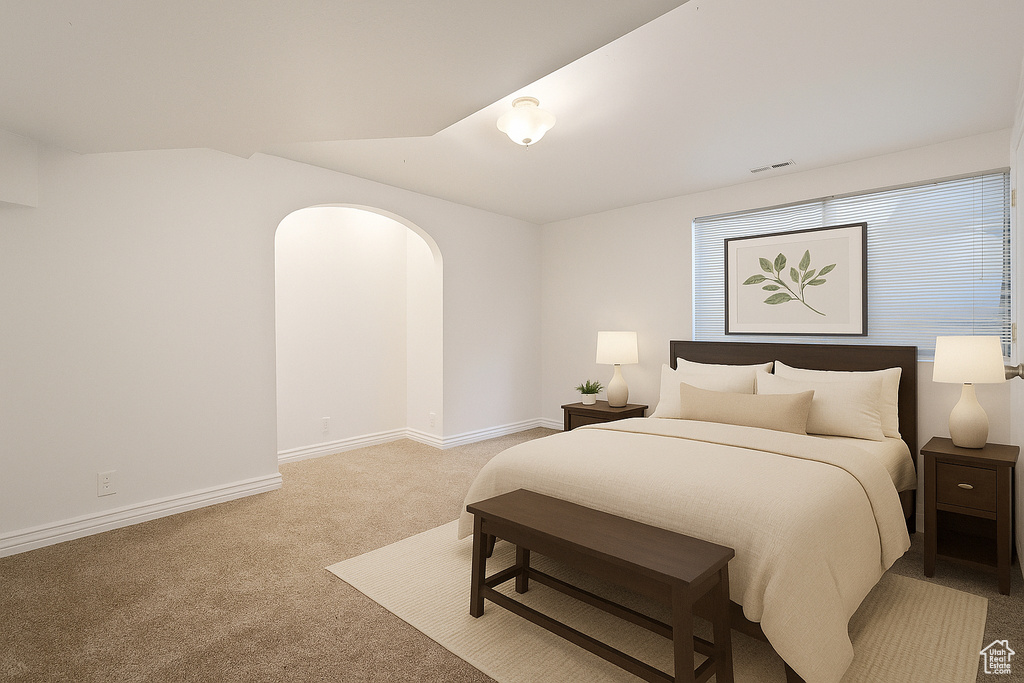Bedroom featuring carpet flooring and arched walkways