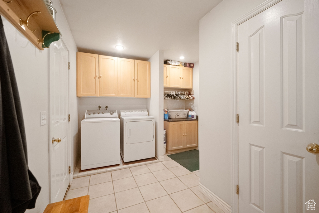 Laundry area featuring cabinet space, washer and dryer, light tile patterned floors, recessed lighting, and baseboards