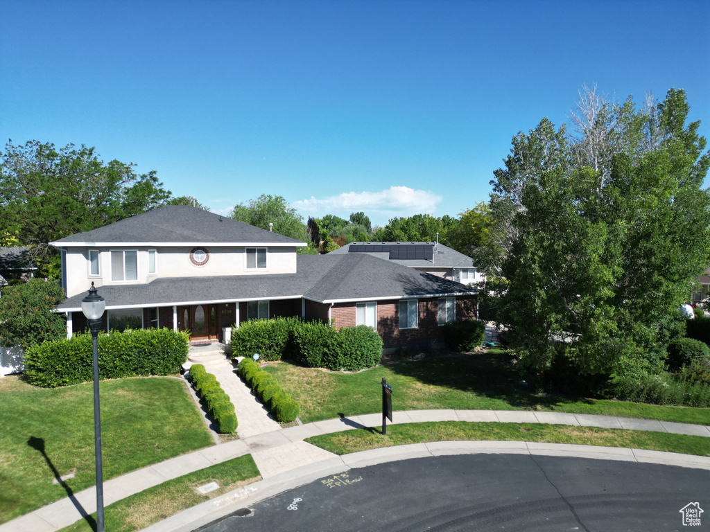 View of front of house featuring a front lawn and covered porch