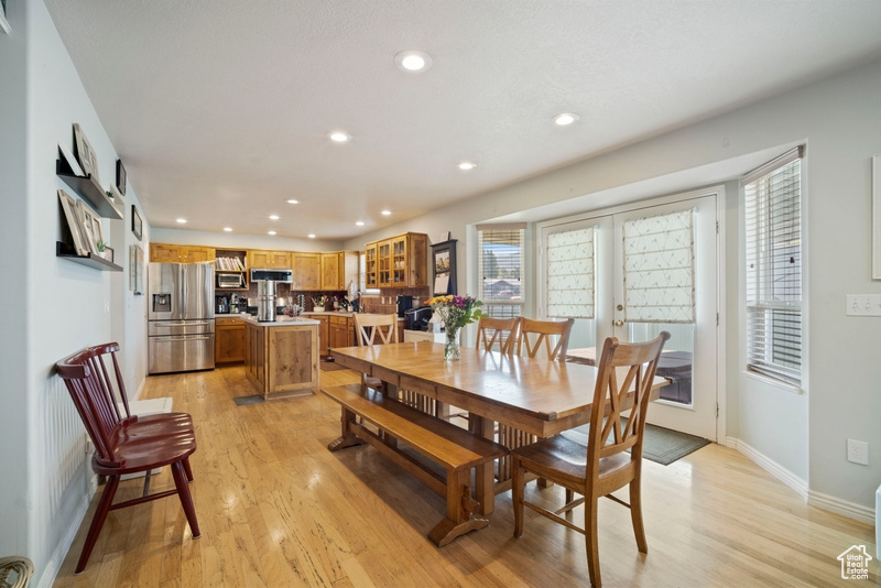 Dining room featuring light wood finished floors, recessed lighting, baseboards, and french doors