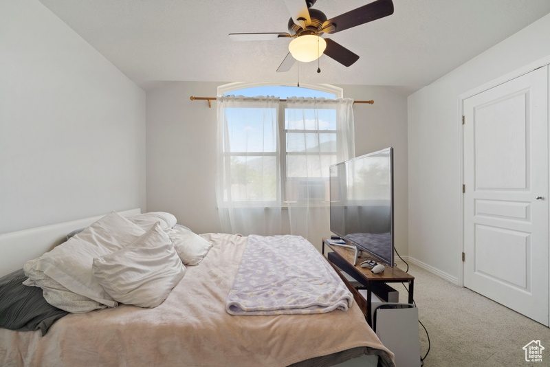 Carpeted bedroom featuring a ceiling fan