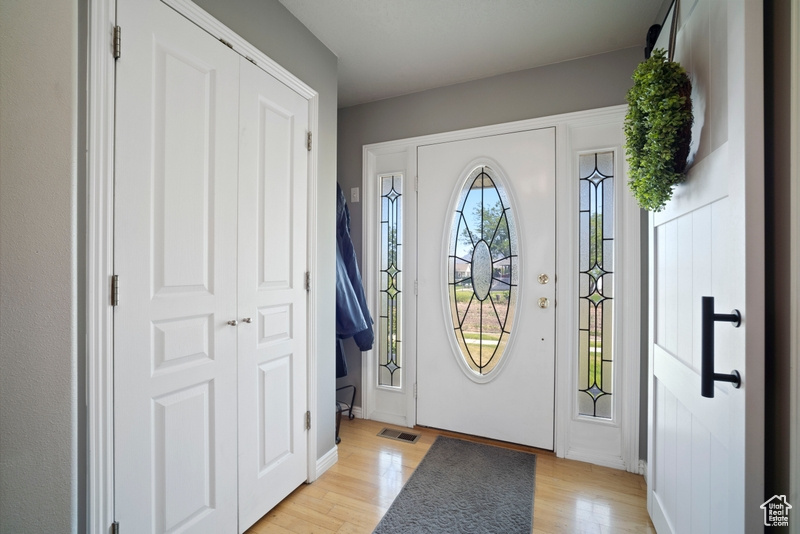 Foyer with light wood-type flooring and baseboards