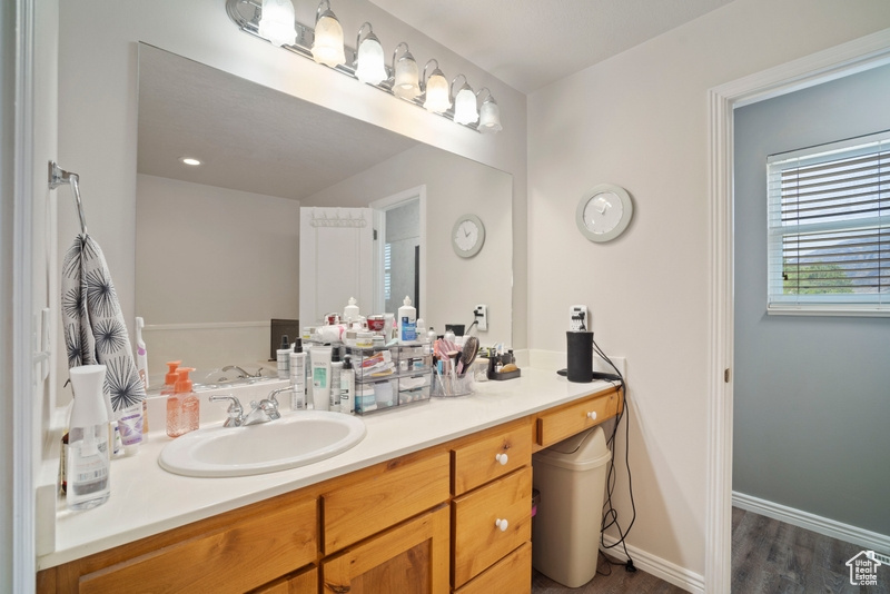 Bathroom with vanity, wood finished floors, and baseboards