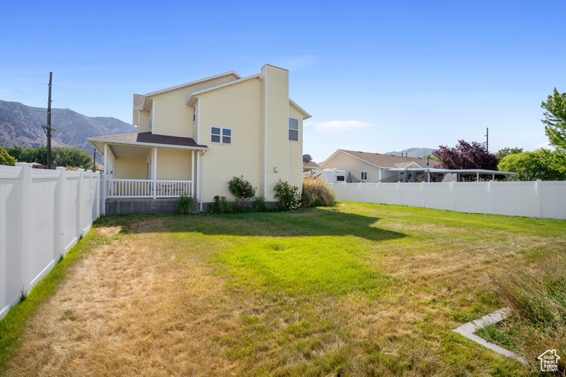 Back of property featuring a mountain view and a porch