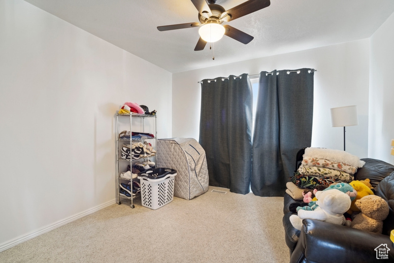 Sitting room with carpet, ceiling fan, and baseboards