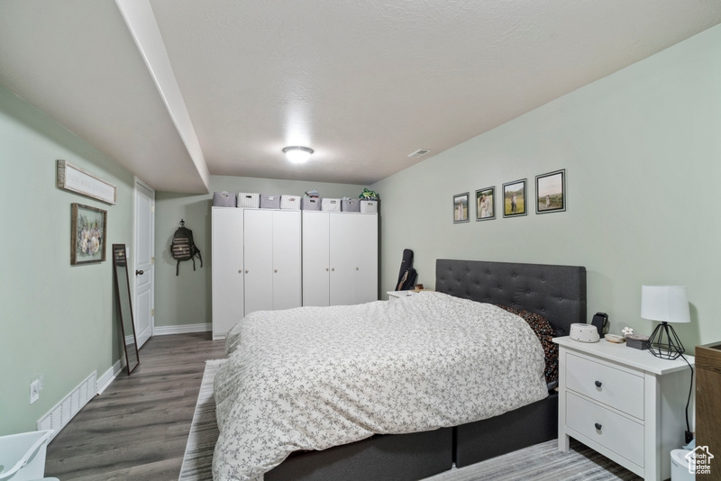 Bedroom with wood finished floors and baseboards