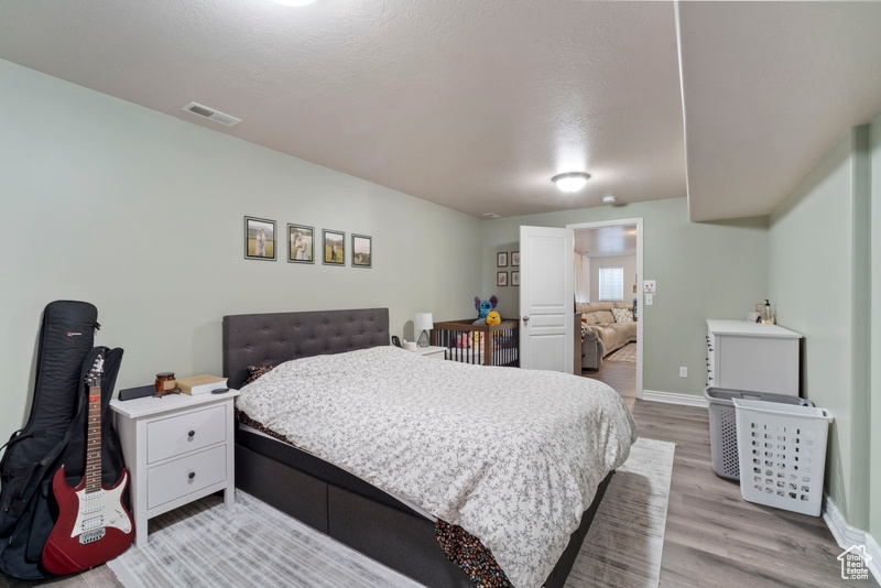 Bedroom with light wood finished floors and baseboards