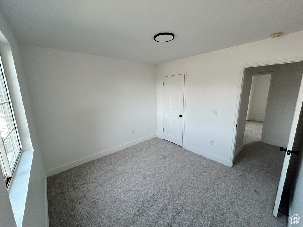 Unfurnished bedroom featuring carpet floors and baseboards