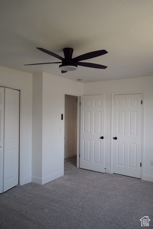 Unfurnished bedroom with carpet floors, baseboards, ceiling fan, and a closet