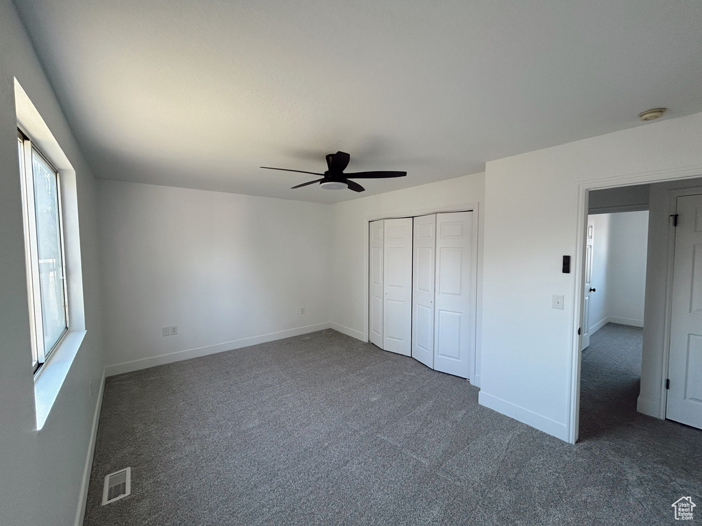 Unfurnished bedroom featuring carpet, ceiling fan, and baseboards