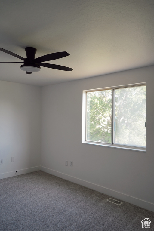 Unfurnished room with ceiling fan, baseboards, and carpet flooring