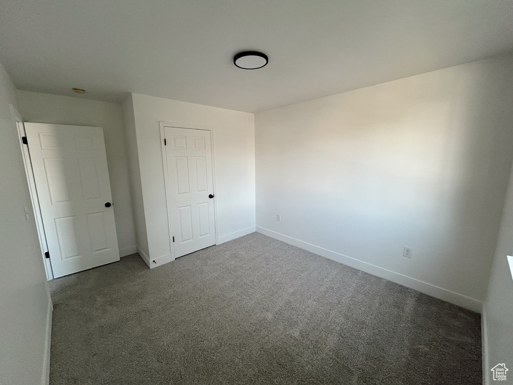 Unfurnished bedroom featuring carpet and baseboards