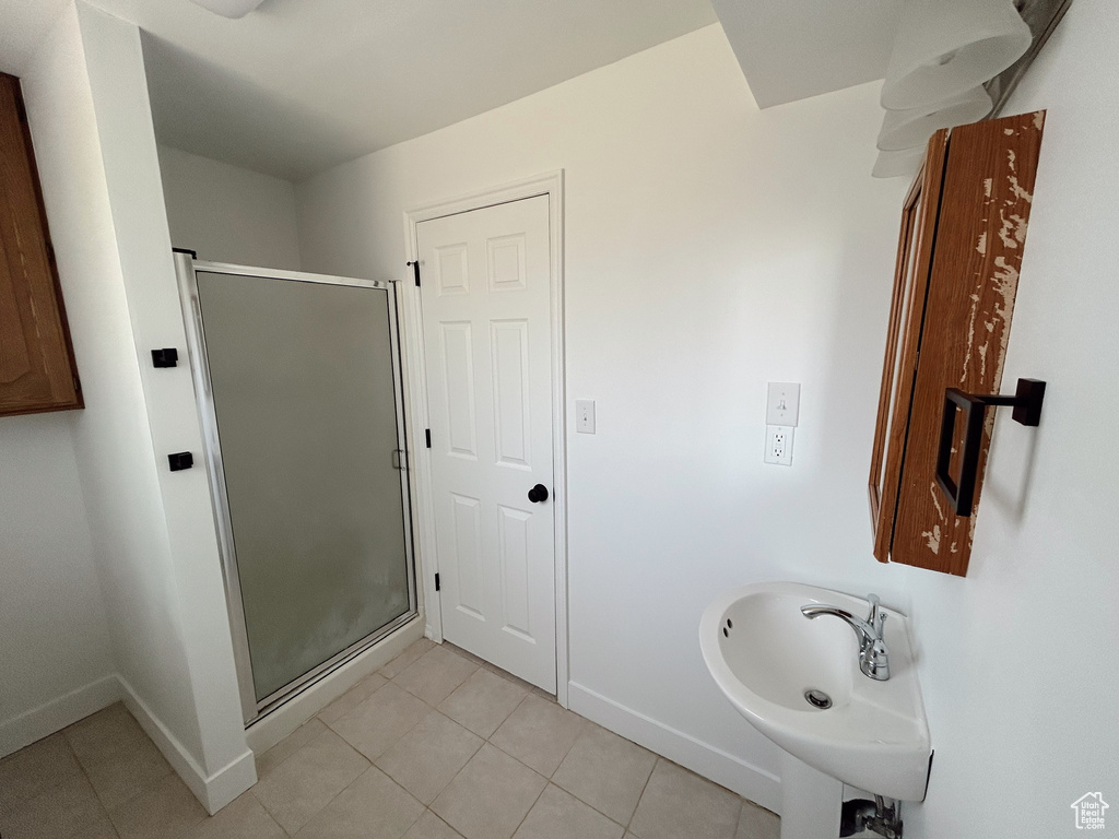 Full bathroom featuring tile patterned floors, baseboards, and a stall shower
