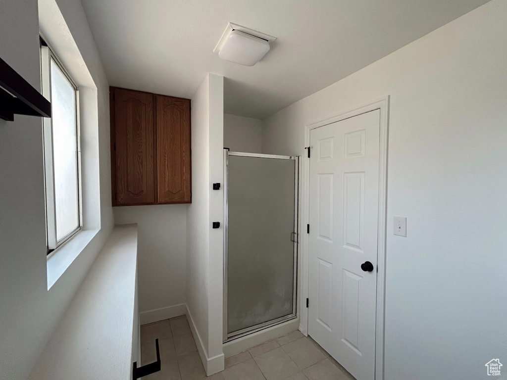 Washroom with light tile patterned flooring and baseboards