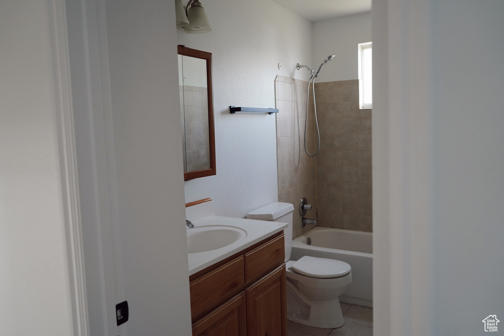 Bathroom with toilet, vanity,  shower combination, and tile patterned flooring