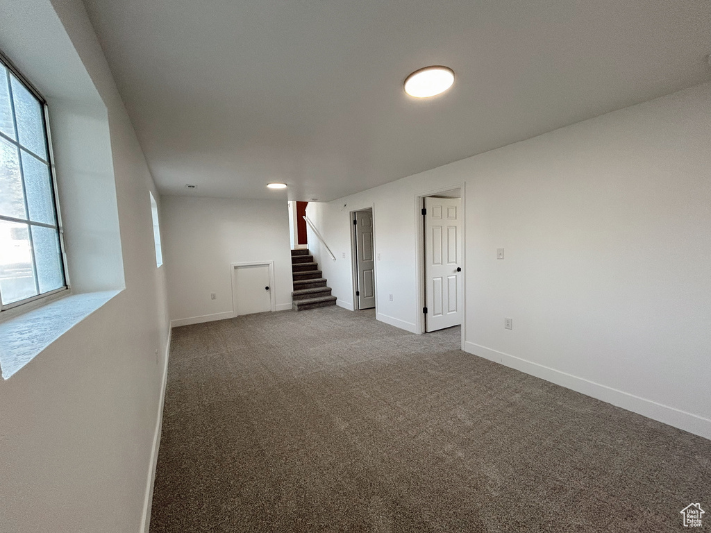 Spare room with baseboards, carpet flooring, and stairway