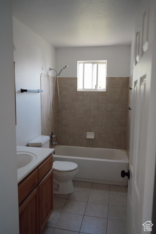 Full bath featuring vanity, toilet, tile patterned flooring, and shower / bathtub combination