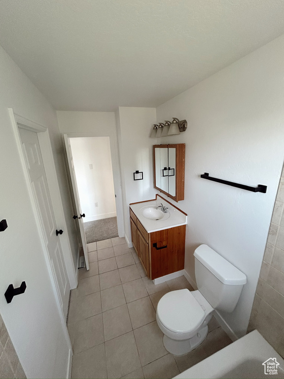 Full bathroom with toilet, vanity, and tile patterned floors