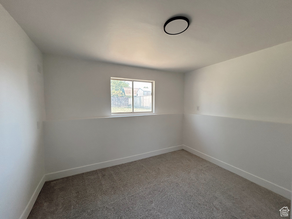 Spare room featuring carpet and baseboards