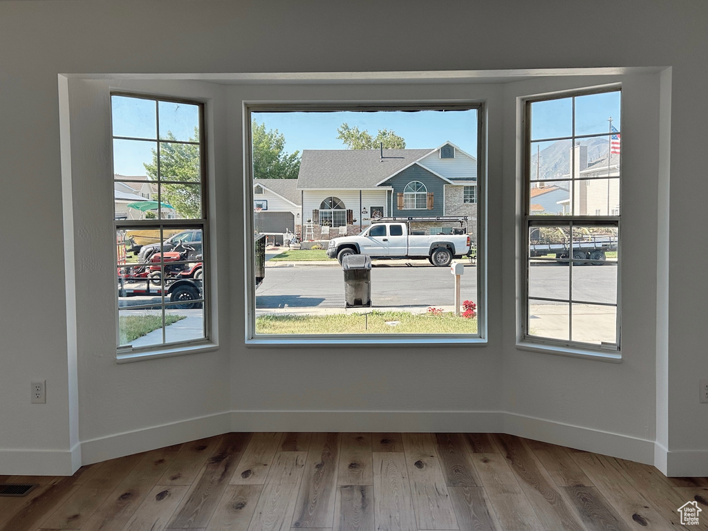 Unfurnished dining area with wood finished floors and baseboards
