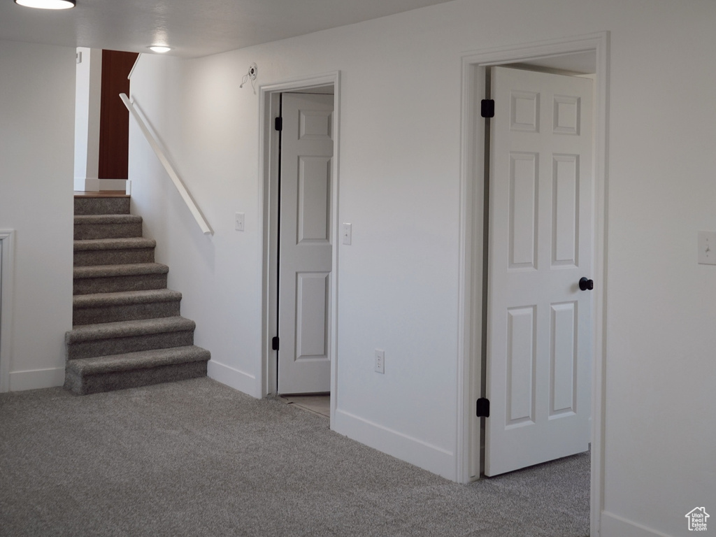 Below grade area with carpet, stairway, and baseboards