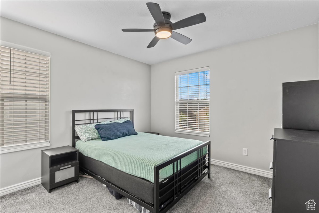 Bedroom featuring baseboards, carpet flooring, and a ceiling fan