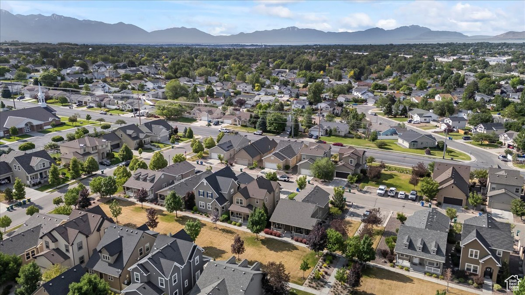 Aerial view of property and surrounding area with a mountain backdrop and nearby suburban area