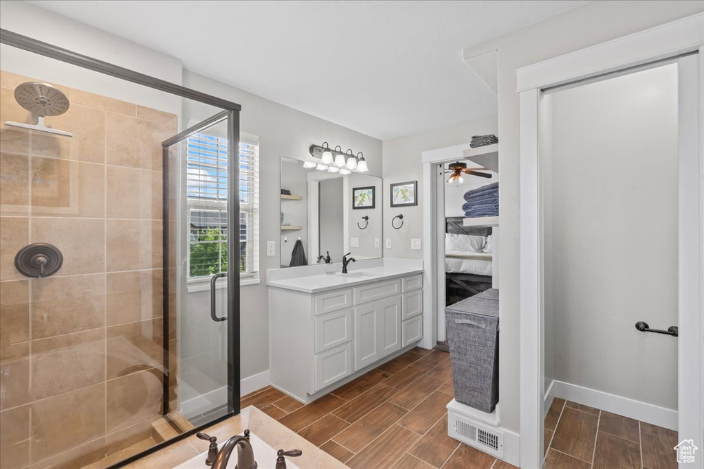 Full bathroom with a stall shower, ensuite bath, vanity, and wood finish floors