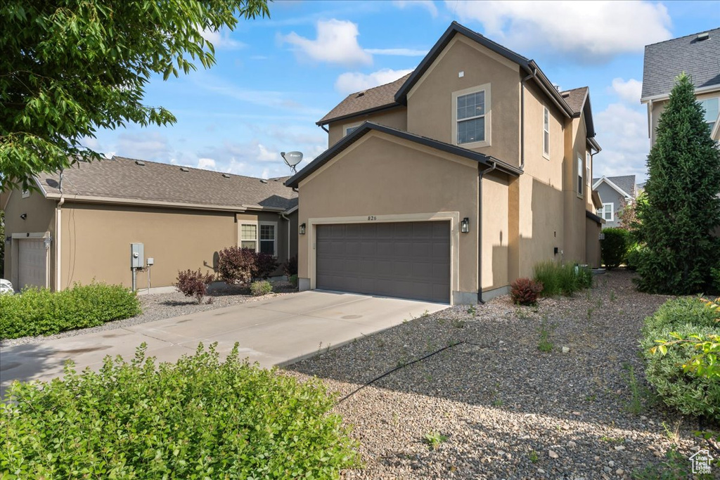 Traditional home featuring stucco siding and driveway