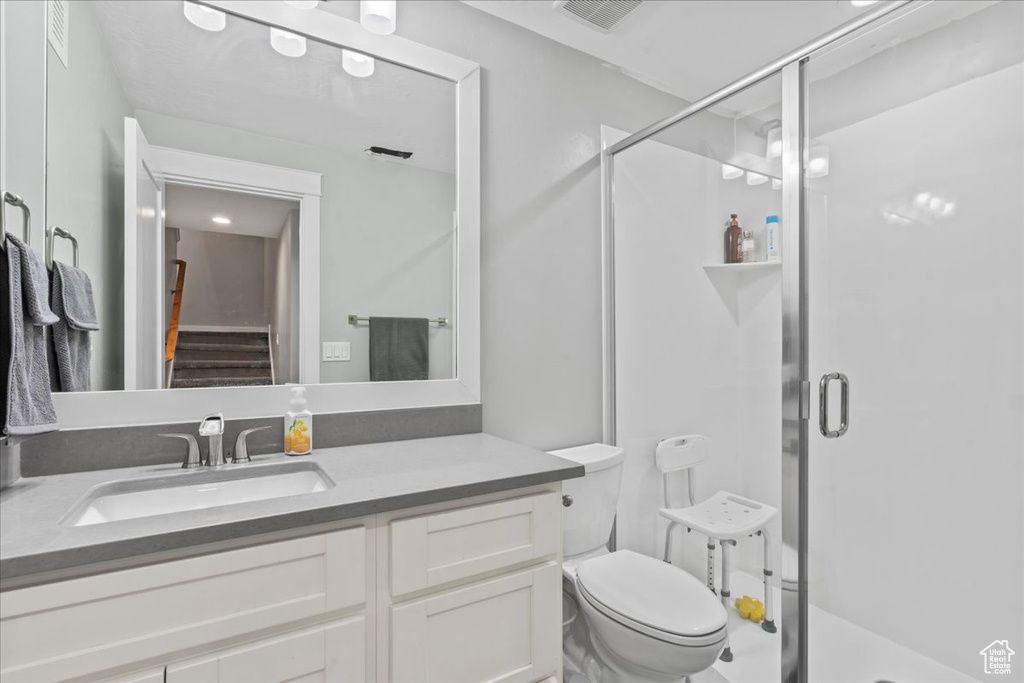 Bathroom with a stall shower, vanity, and toilet