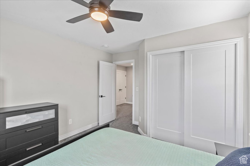 Carpeted bedroom featuring baseboards, a closet, and ceiling fan