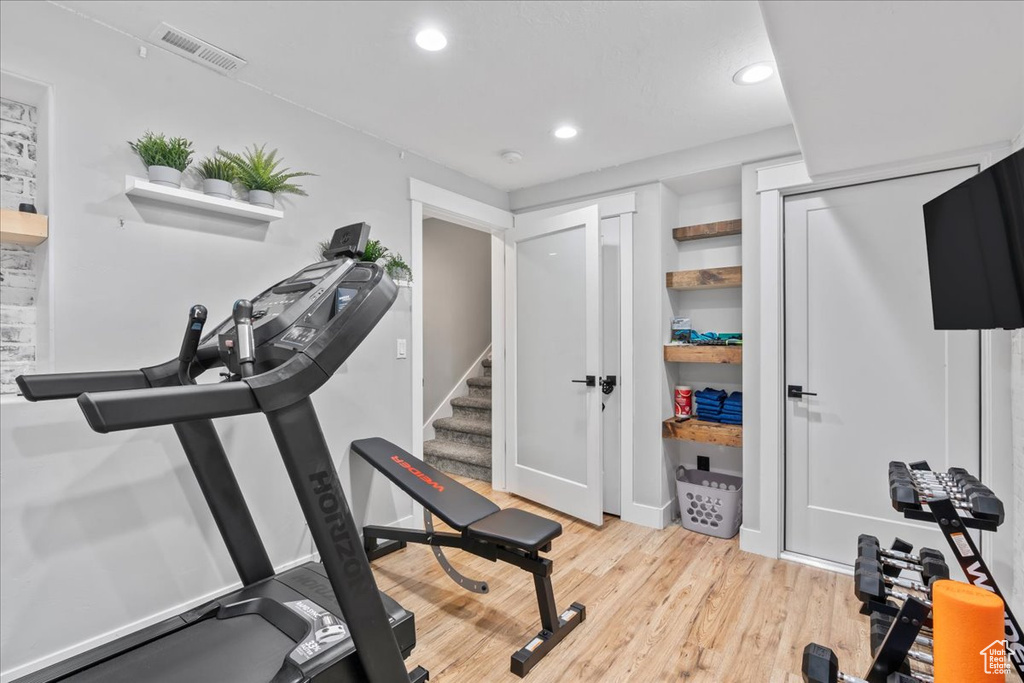 Workout area with recessed lighting and light wood-style floors