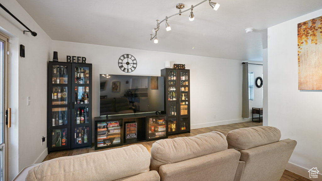 Living room with wood finished floors, baseboards, and track lighting