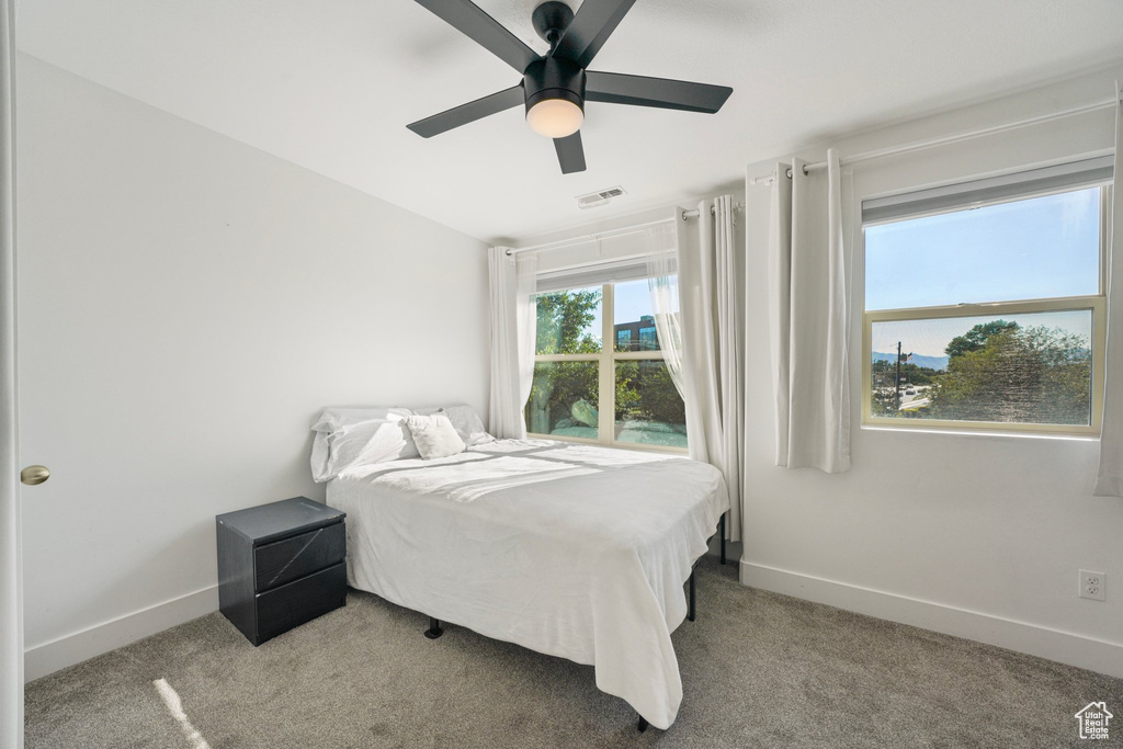 Carpeted bedroom featuring baseboards and a ceiling fan