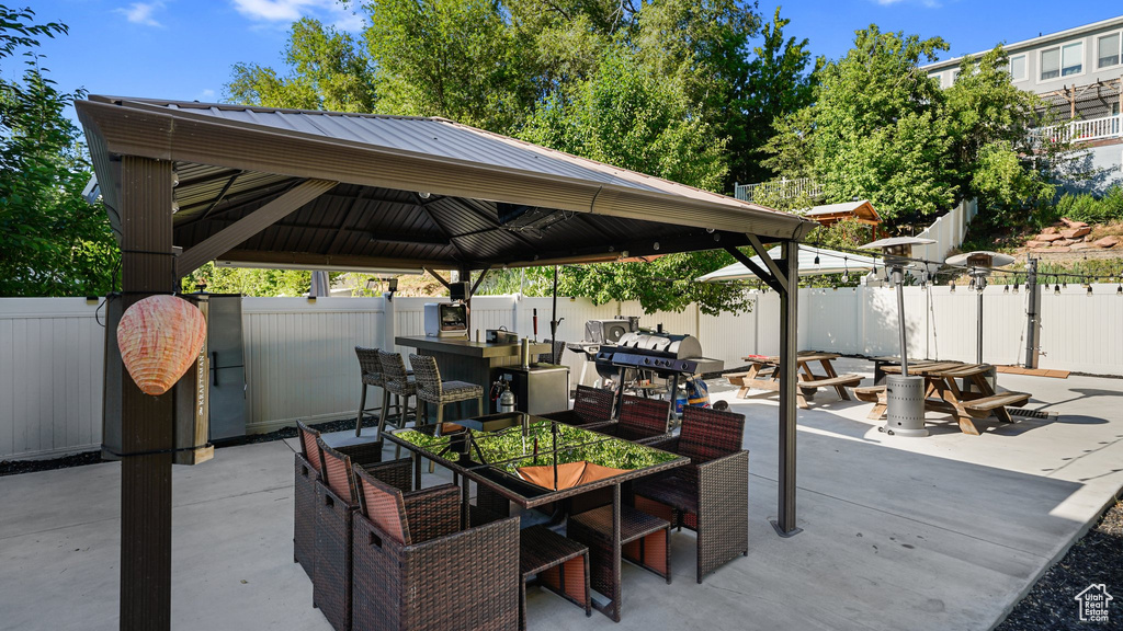 Fenced backyard featuring a gazebo, a patio area, and outdoor dining space